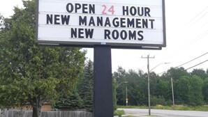 A sign for a hotel named 'Nipissing Inn' with a 24-hour open notice and mentions new management and rooms. - Nipissing Inn (North Bay)