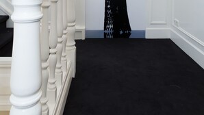 A staircase with white balusters and a black carpeted floor. - Le Theatre Hotel (Maastricht)