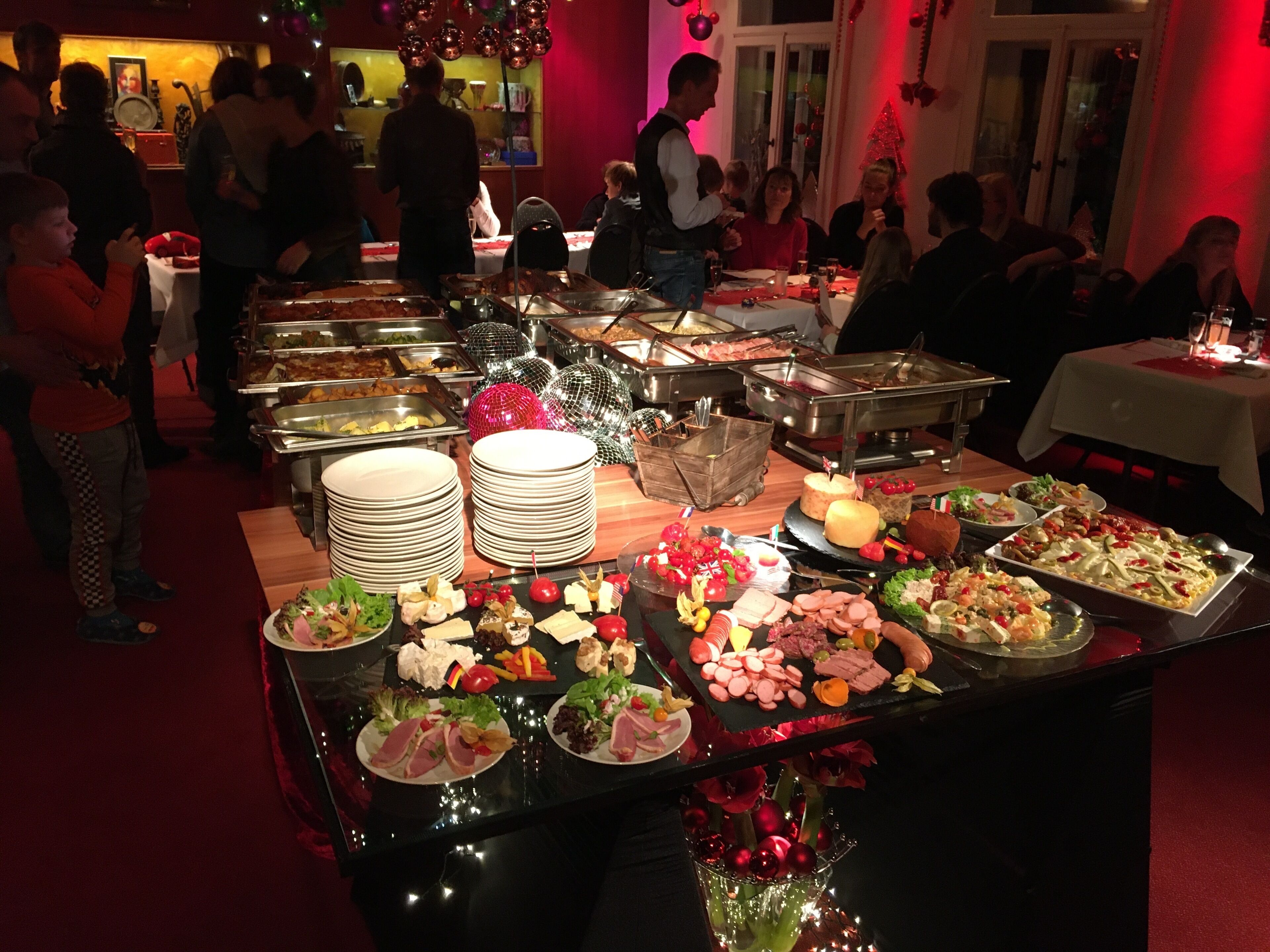 Ein Buffet mit verschiedenen Speisen und ein Weihnachtsbaum im Hintergrund.