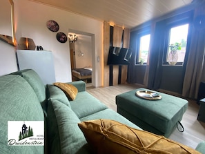 Suite de lujo, 1 cama King size, sauna, vista a la colina | Área de sala de estar | Libros