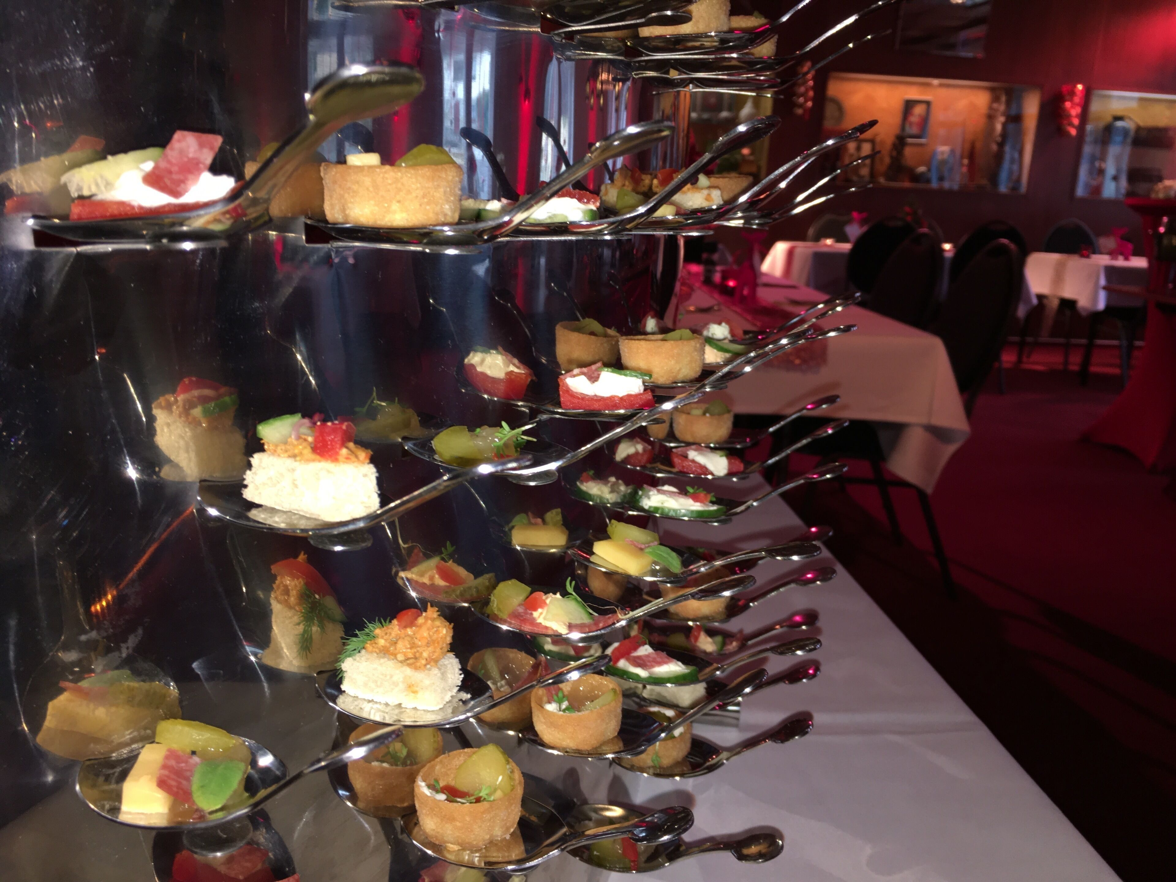 A multi-tiered dessert display with various small dishes and utensils.