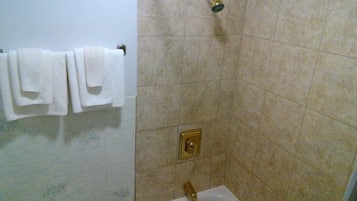 Un baño con ducha, lavamanos y un perchero para toallas.