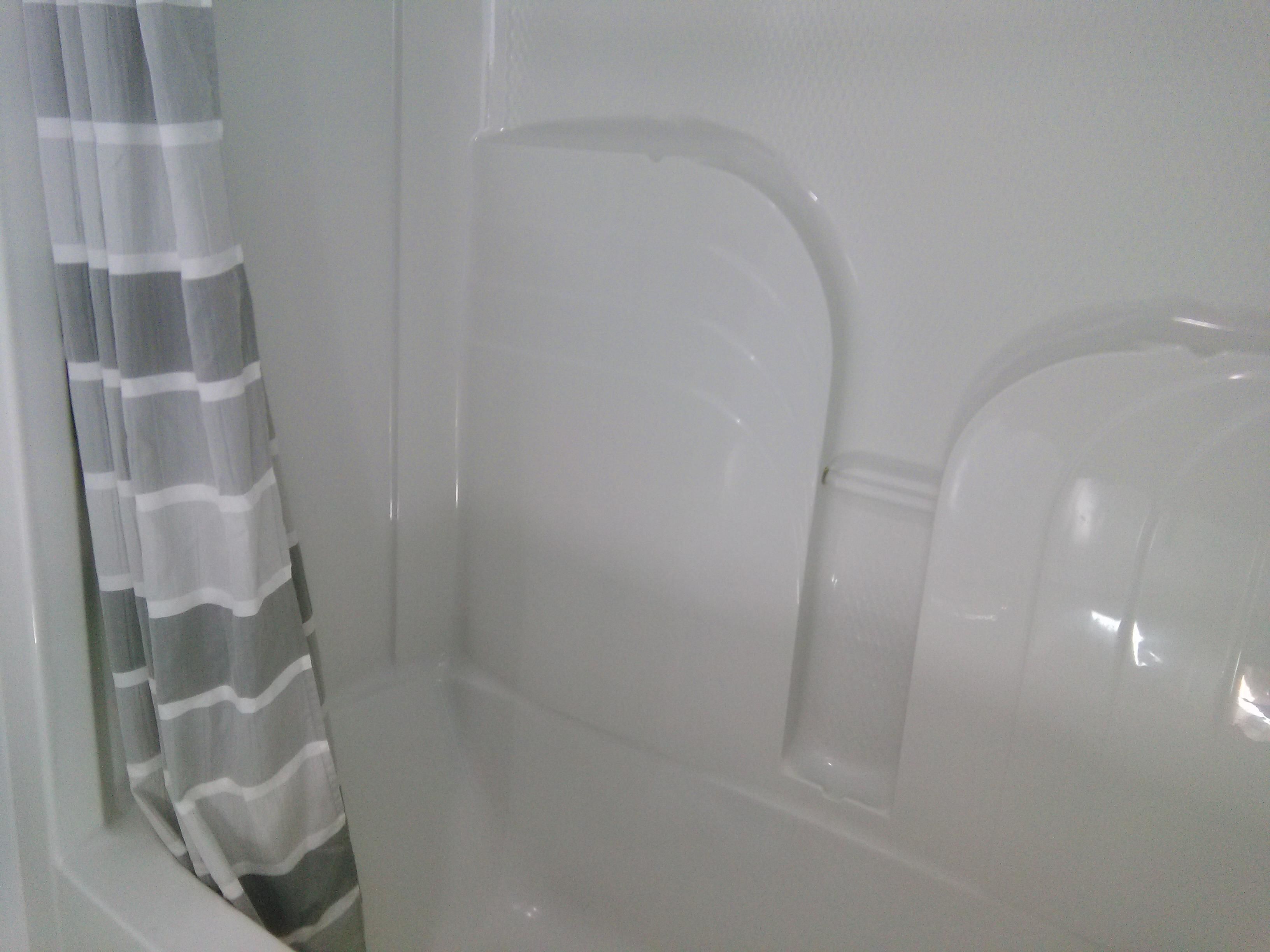 Un baño con cortina de ducha, bañera y retrete.