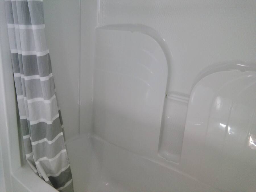Un baño con cortina de ducha, bañera y retrete.