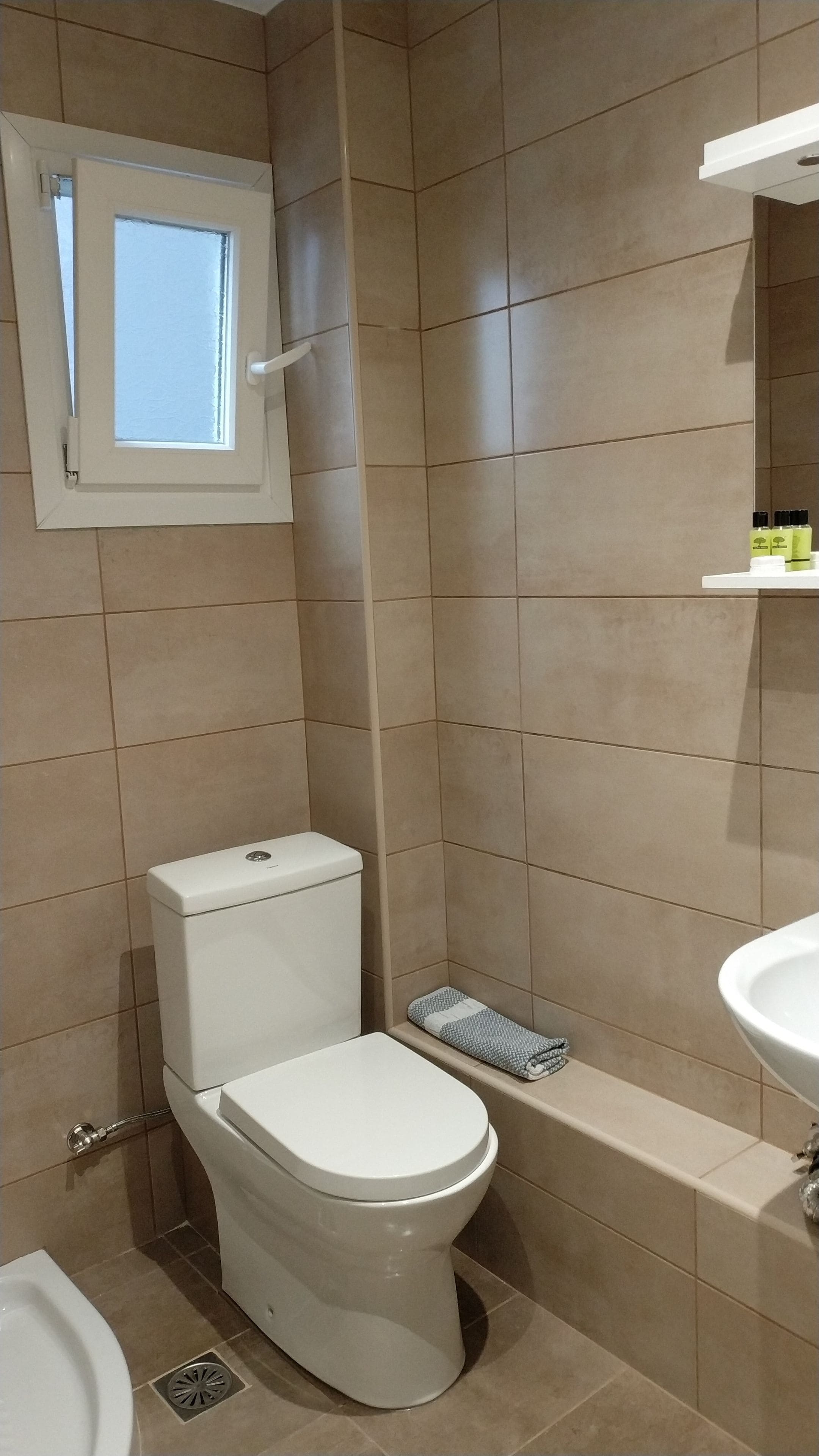Une salle de bain comprenant des toilettes, un lavabo et un espace douche.