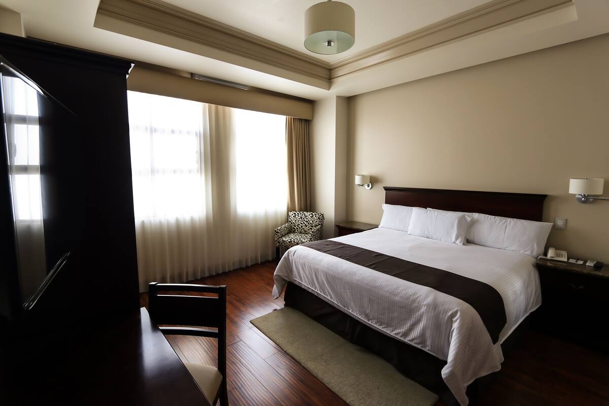 Ropa de cama de alta calidad y caja de seguridad en la habitación