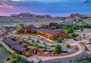 Un resort con varias edificaciones de madera, zonas de estar al aire libre y un jardín ajardinado.