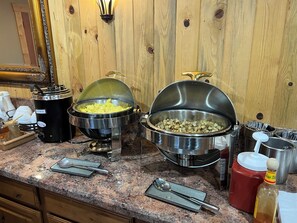 A buffet setup with various food items and kitchenware on a granite countertop. - Desert Rose Resort & Cabins (Bluff)