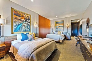 A hotel room with two beds, a desk, and a large painting on the wall. - Desert Rose Resort & Cabins (Bluff)