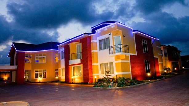 Un hotel de varios pisos con diseño moderno, con balcones y una entrada bien iluminada.