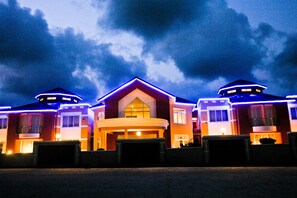 A hotel with a central building and two smaller structures on either side, connected by a covered walkway. - Birdrock Hotel (Anomabo)
