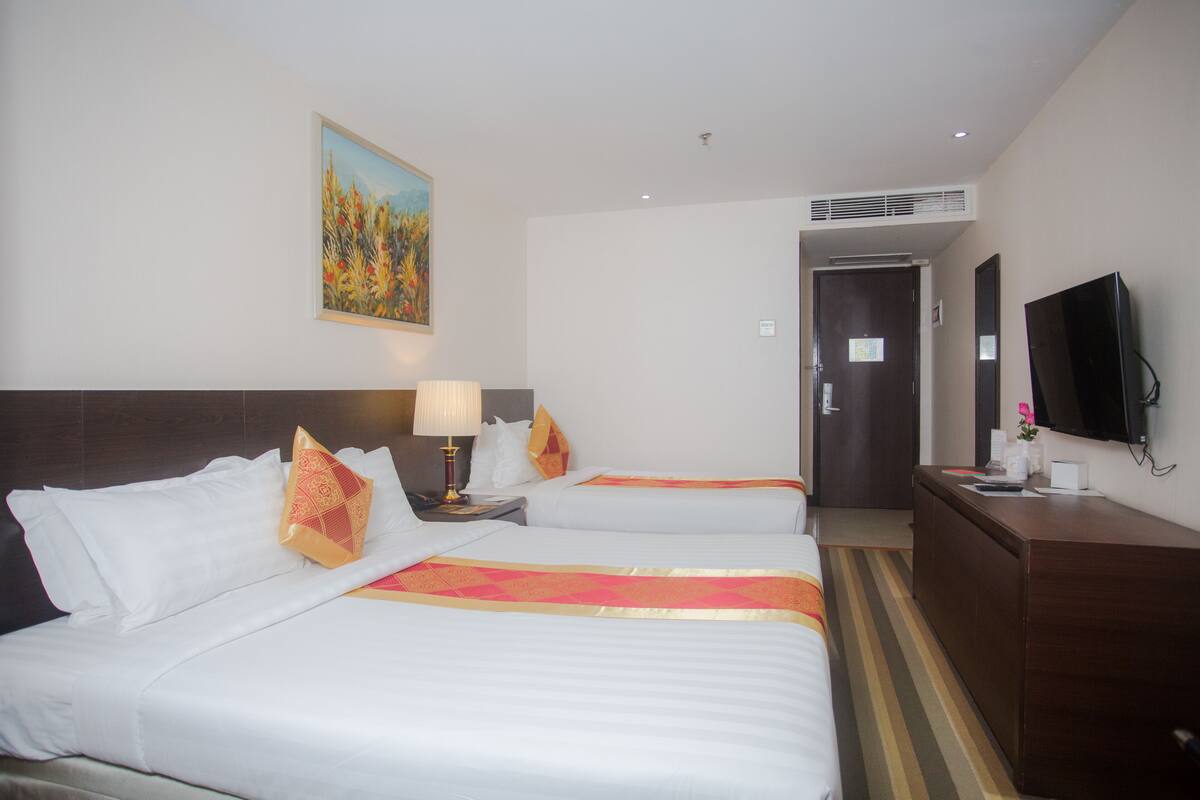 Deluxe Triple Room | Minibar, in-room safe, desk, blackout drapes