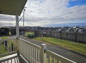 Un espace extérieur abrité doté d’une terrasse en bois, d’une cour clôturée et d’une vue sur l’océan.