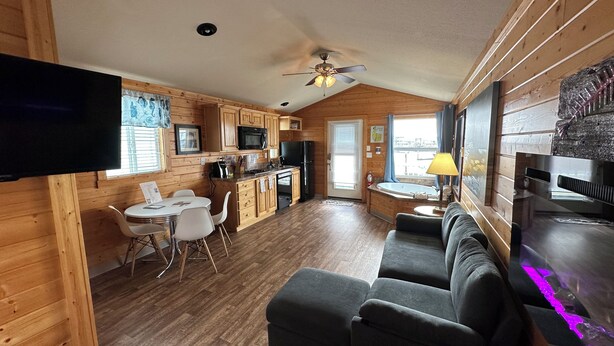 Une chambre confortable, aménagée dans le style d’un chalet, avec un coin repas, une kitchenette et une grande fenêtre donnant sur un paysage magnifique.