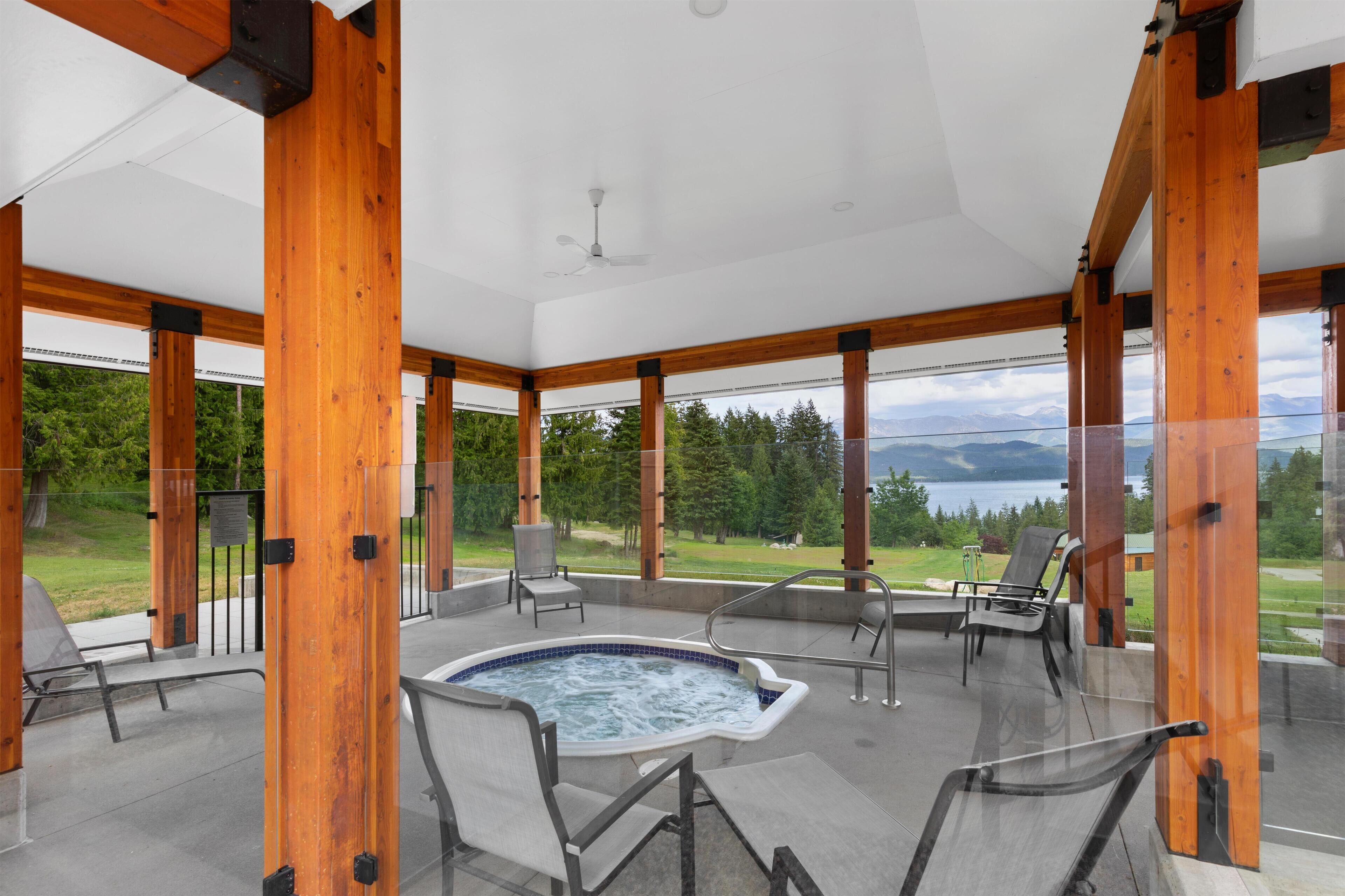 Un vaste espace extérieur doté d’un jacuzzi, de coins salon et offrant une vue sur les montagnes et la verdure.