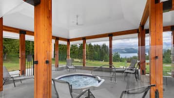 Un vaste espace extérieur doté d’un jacuzzi, de coins salon et offrant une vue sur les montagnes et la verdure.