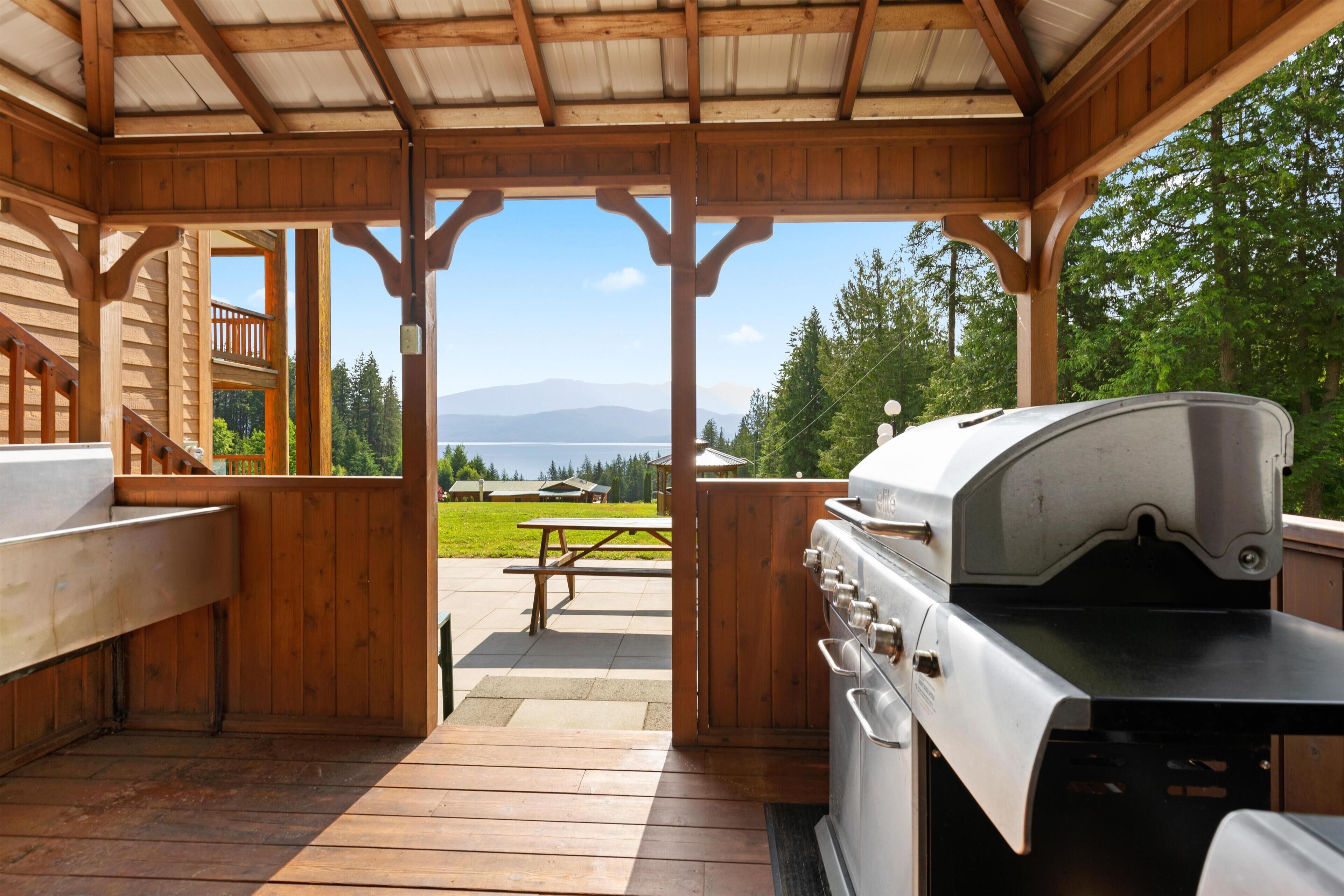 Une cabane en bois avec un barbecue et une table de pique-nique.