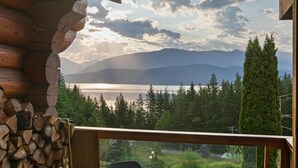 Une cabane en rondins offrant une vue sur les montagnes et un lac.