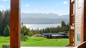 Une cabane en bois avec vue sur un lac et des montagnes.