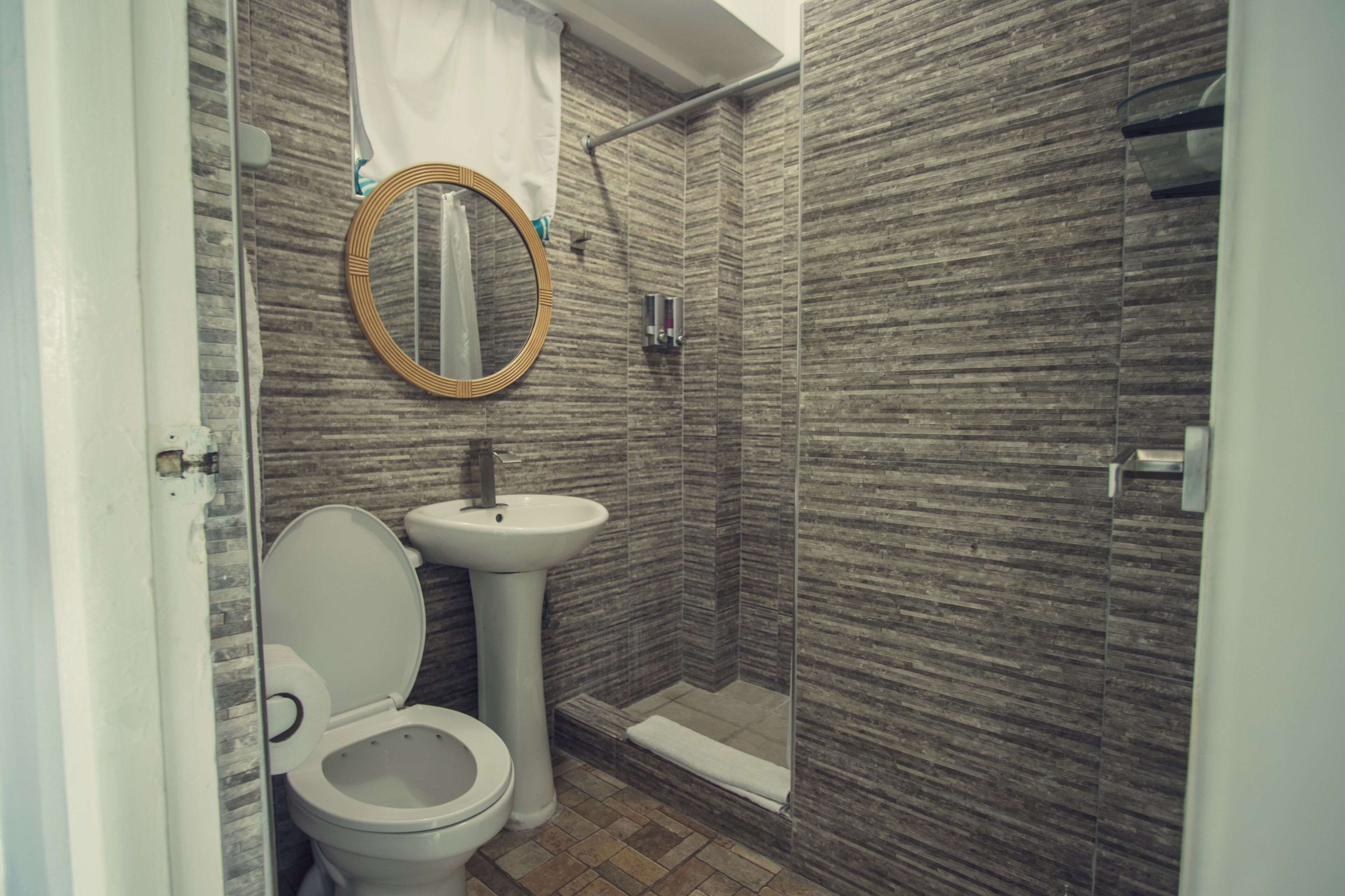 Un baño con inodoro, lavabo y ducha.