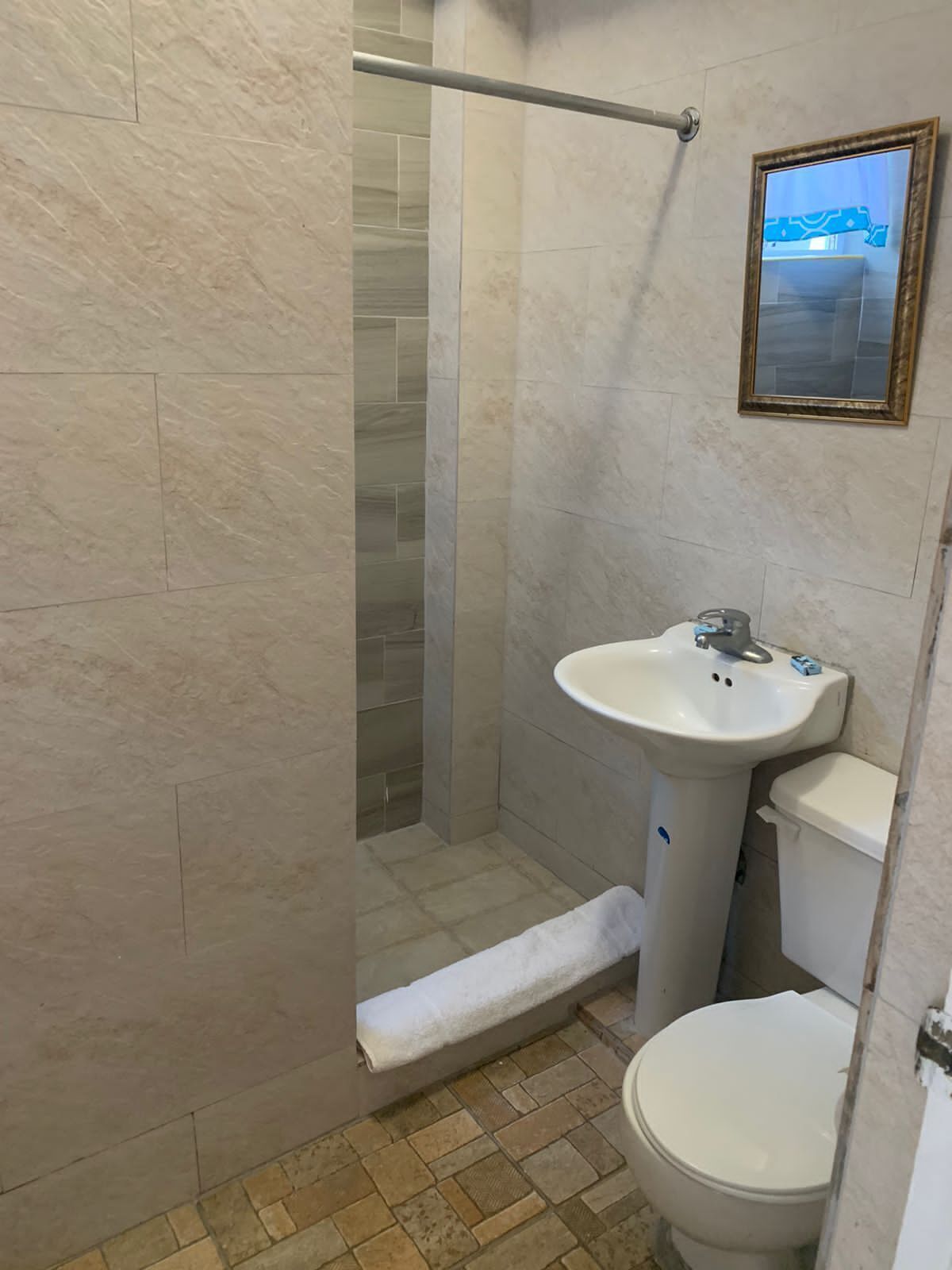 Ein Badezimmer mit Dusche, Toilette und Waschbecken.