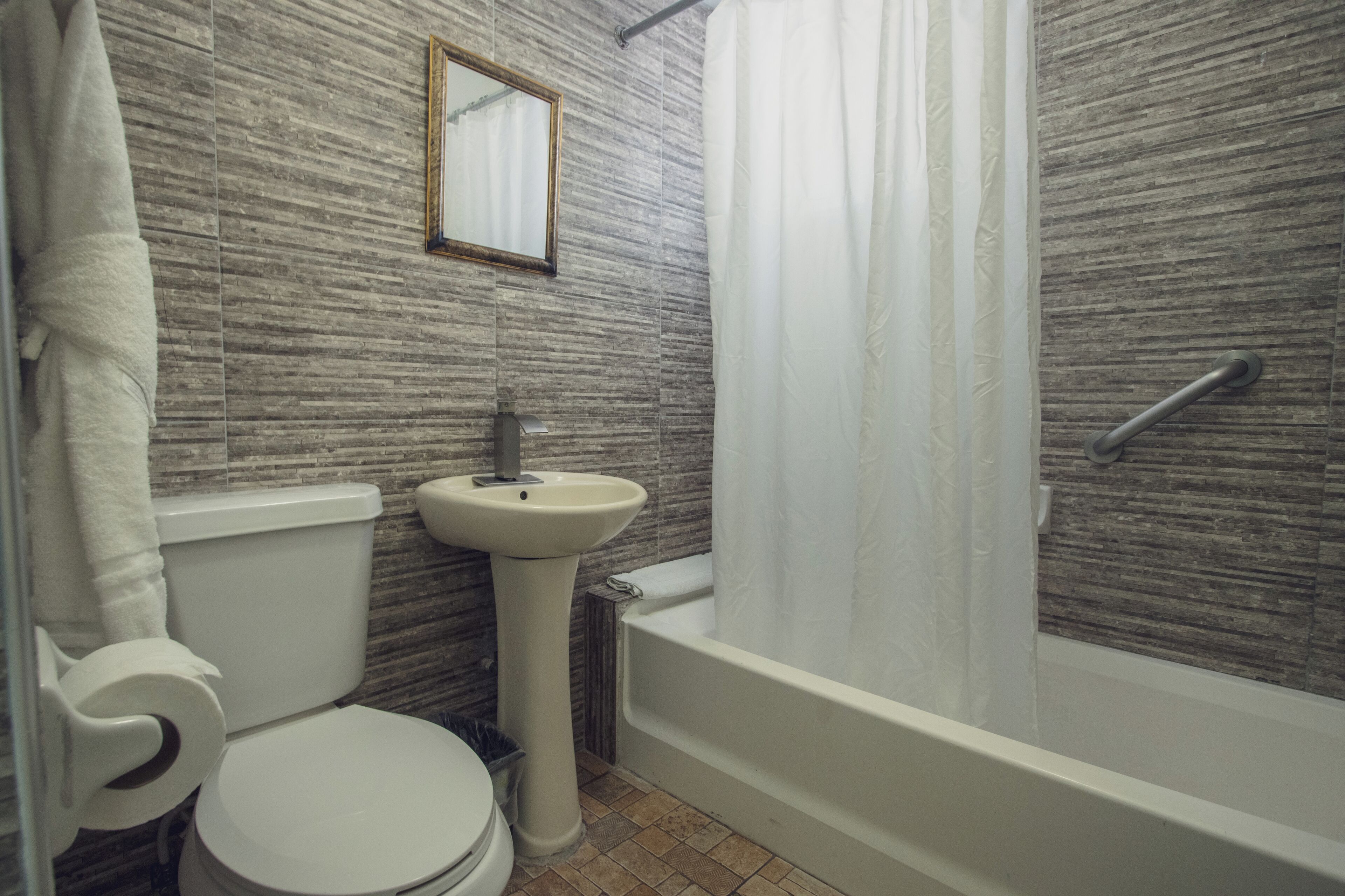 A bathroom with a toilet, sink, and bathtub.