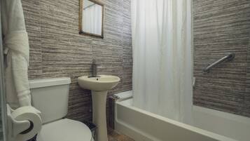 A bathroom with a toilet, sink, and bathtub.