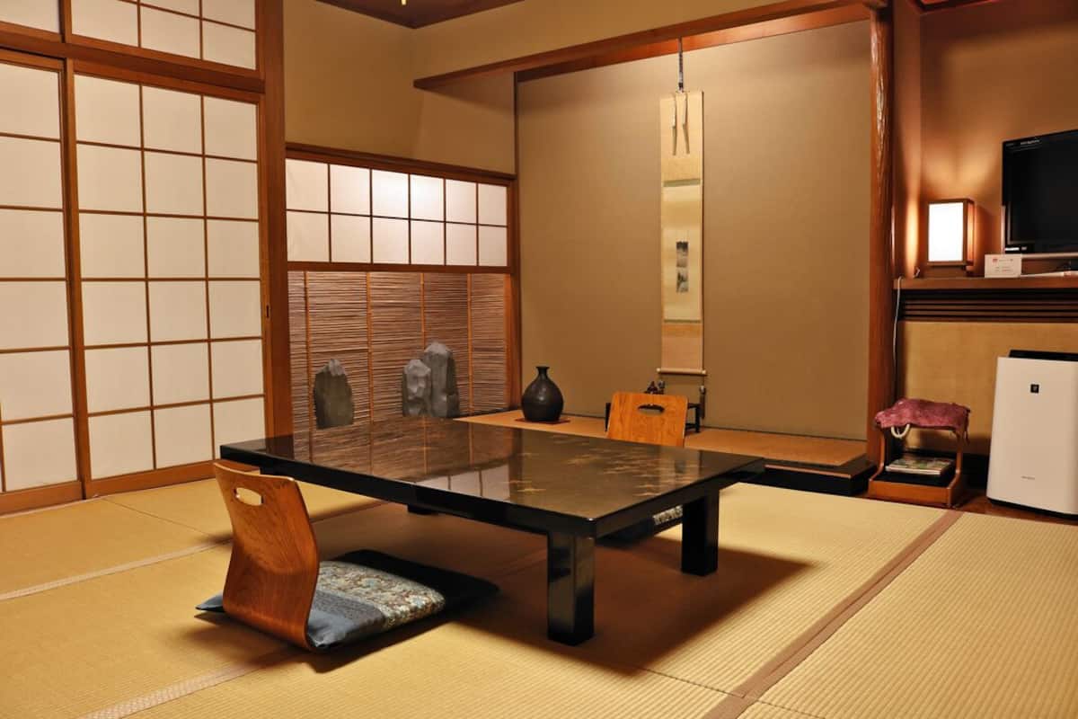 A traditional Japanese room with tatami flooring, a low table, and sliding doors.