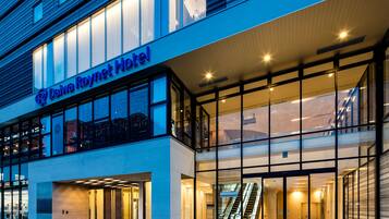 Daiva Roynet Hotel features a modern architectural design with a glass facade and a prominent entrance.