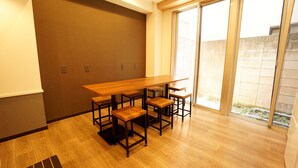 Un comedor con una mesa de madera y cuatro taburetes de bar.