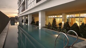 Um hotel moderno com piscina, janelas amplas e interior bem iluminado.