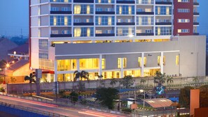 Um hotel de vários andares com um design arquitetônico moderno, com varandas e janelas amplas.