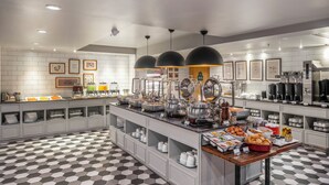 A modern kitchen with white tiled walls, black and white checkered floor, and various kitchen appliances and utensils. - Vince Hotel Pratunam (Bangkok)