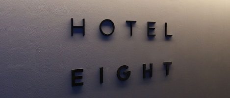 A wall with the text "HOTEL EIGHT HOURS" in capital letters.