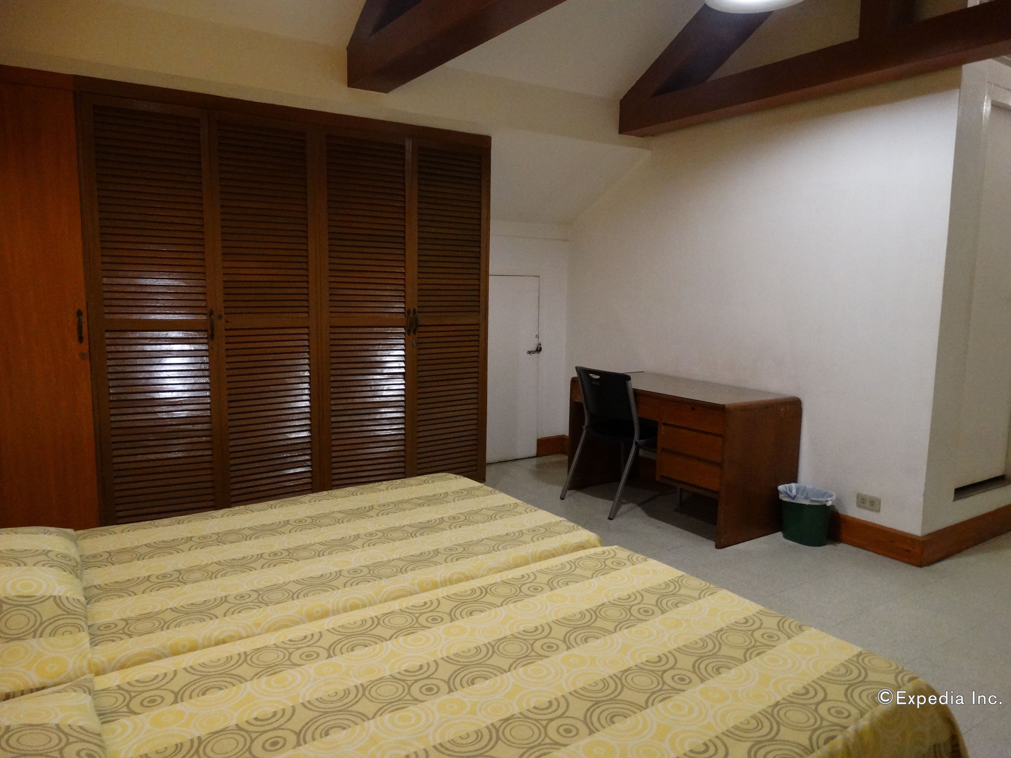 Quarto com cama, escrivaninha e guarda-roupa.