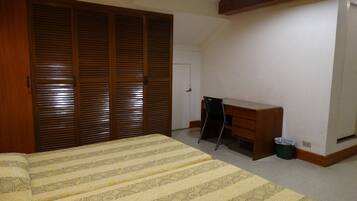 Quarto com cama, escrivaninha e guarda-roupa.