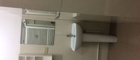 A bathroom with a sink, mirror, and a towel rack.