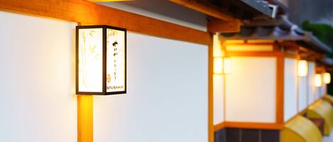 A row of traditional Japanese lanterns with calligraphy on the wall.