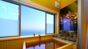 A wooden bathtub with a view of the sea through large windows. - Tenku Yubo Seikaiso (Beppu)