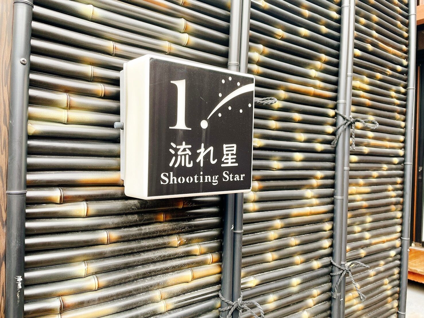 A sign with the number 1 and the text "Shooting Star" in both English and another language.