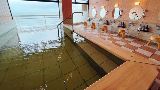 A spa area with a wooden floor, a pool, and multiple wooden stools. - Tenku Yubo Seikaiso (Beppu)