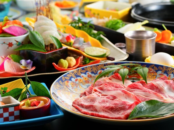 A variety of dishes and food items on a table, including a plate with sliced meat and vegetables. - Tenku Yubo Seikaiso (Beppu)