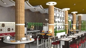 Un intérieur de restaurant moderne avec des tables rondes, des piliers en osier et un mur végétal.