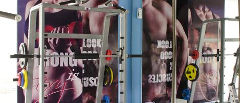 Un gimnasio con equipo de ejercicio y carteles motivacionales en las paredes.