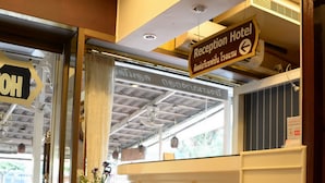 A reception desk with a sign indicating the direction to the reception and hotel. - At Bangkok Hotel (Bangkok)