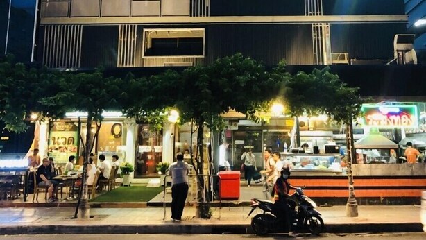 A modern building with a flat facade, large windows, and a well-lit entrance area. - At Bangkok Hotel (Bangkok)