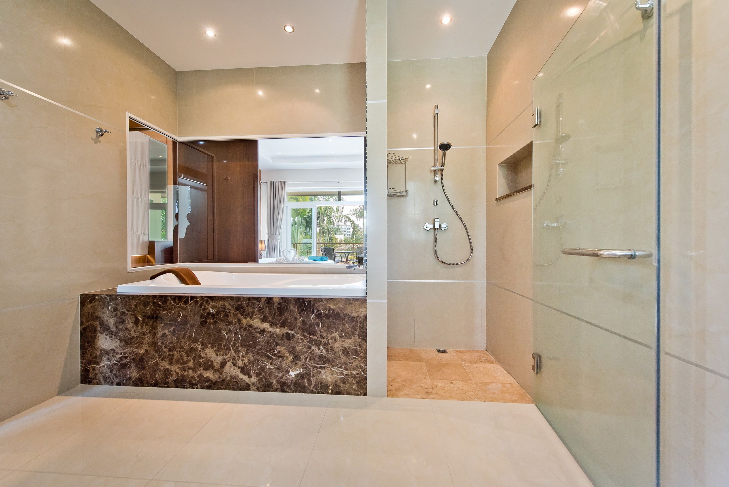 Une salle de bain moderne avec un meuble-lavabo en marbre, une douche à parois de verre et un grand miroir.