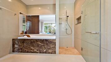 Une salle de bain moderne avec un meuble-lavabo en marbre, une douche à parois de verre et un grand miroir.