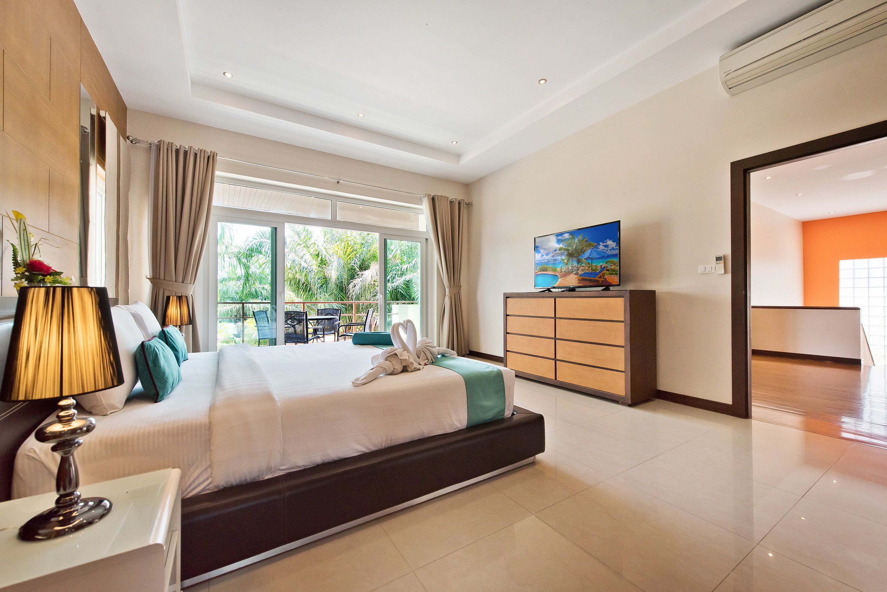 Une chambre d’hôtel moderne dotée d’un grand lit, d’une télévision, d’une commode et offrant une vue sur l’extérieur.