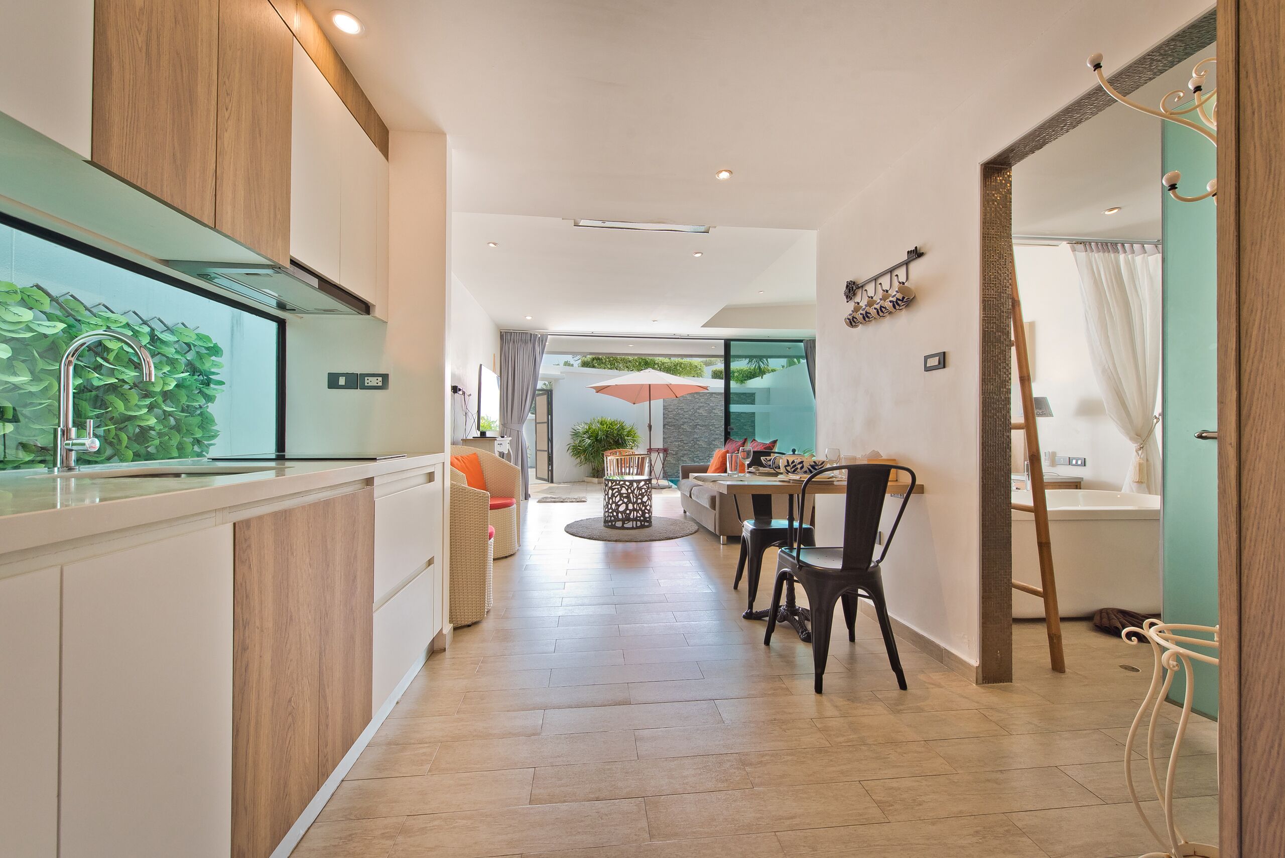 A modern kitchen with wooden cabinets, a built-in sink, and a dining area with a table and chairs.